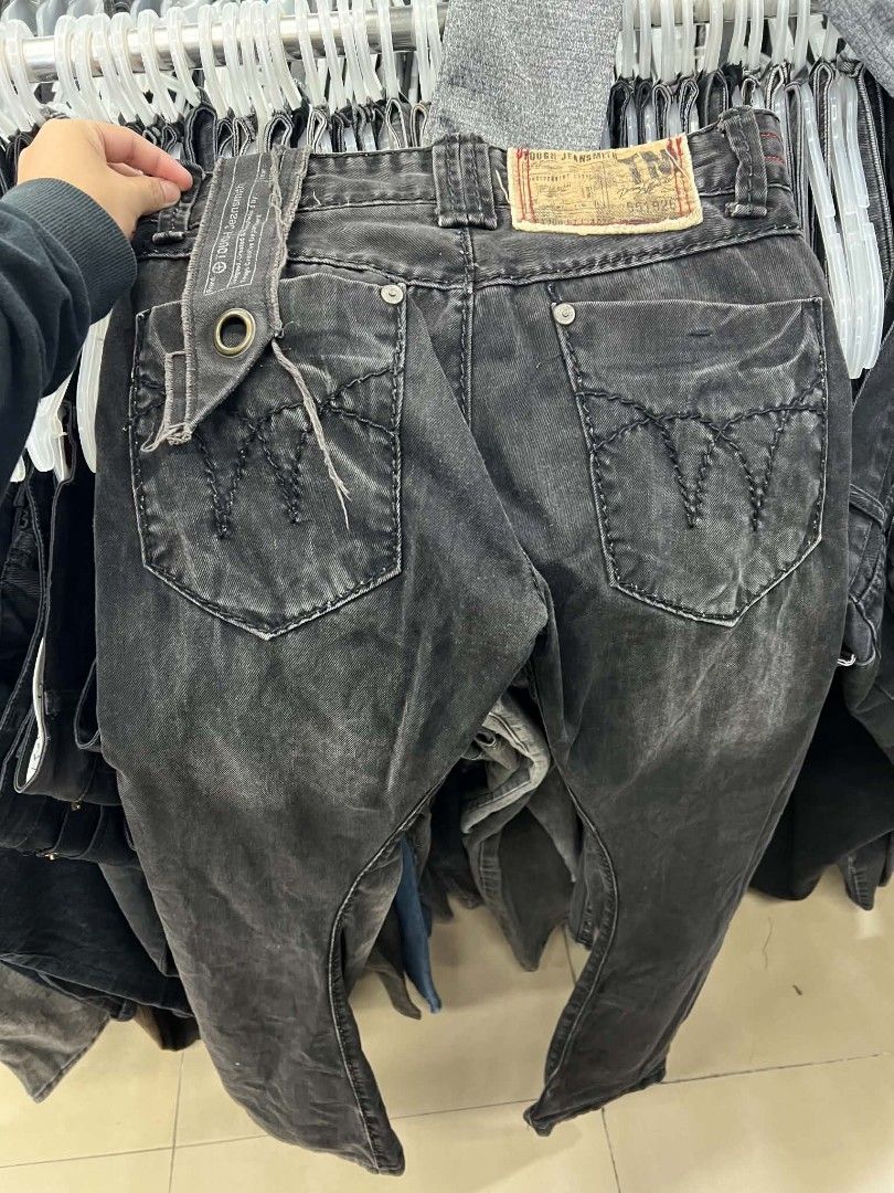 Tough Jeanssmith Black Distressed Denim Jeans (Category: Jeans) located in Urdaneta. Submitted by jayceegarage (Listing ID 1466721079, Image 2). Description: - Brand: Tough Jeanssmith - Color/Finish: Black with a heavily washed, distressed look - Fit: Straight cut, highly durable fabric - Unique Details: Metal grommet strap hanging from the back pocket and classic zig-zag stitching - Branding: Vintage 1957 tag on the waistband - Condition: Excell