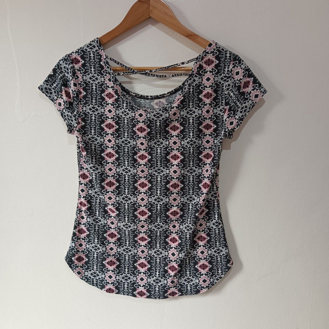 Tribal/Geometric Patterned Top (Category: Blouses) located in Subic. Submitted by mustardt_ (Listing ID 1466616334, Image 2). Description: A short-sleeve scoop-neck shirt featuring a black, pink, and white geometric tribal pattern with a stylish criss-cross cage strap detail across the upper back and a curved hemline. size: 15.5in x 24in code: c812.