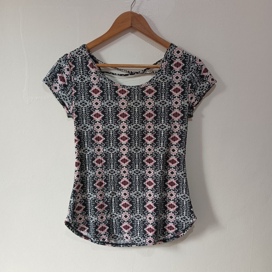 Tribal/Geometric Patterned Top (Category: Blouses) located in Subic. Submitted by mustardt_ (Listing ID 1466616334, Image 1). Description: A short-sleeve scoop-neck shirt featuring a black, pink, and white geometric tribal pattern with a stylish criss-cross cage strap detail across the upper back and a curved hemline. size: 15.5in x 24in code: c812.