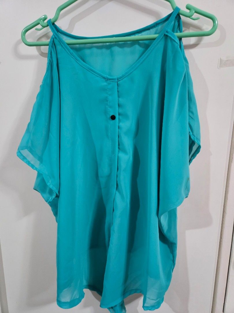 Turquoise Chiffon Short Sleeve Blouse (Category: Blouses) located in Caloocan City. Submitted by rm.diaz (Listing ID 1466751767, Image 1). Description: - Color: Bright turquoise - Material: Lightweight chiffon with a slight sheer look - Design: Short sleeves, simple round neckline, and single front button detail - Style: Casual, versatile for pairing with jeans or skirts - Condition: Clean and ready to go.