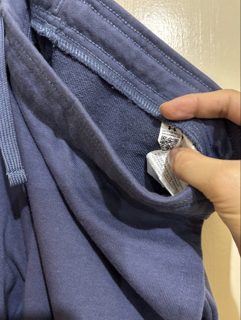 Under Armour Blue Joggers Sweatpants (Category: Joggers) located in Balayan. Submitted by authenticfindsbymrb (Listing ID 1466702462, Image 3). Description: - Brand/Item: Blue Under Armour sweatpants - Fit: Standard fit with adjustable drawstring waist and cuffed ankles - Design: Bright orange logo graphic on the right leg - Pockets: Two deep side pockets with mesh lining - Material: Soft cotton blend with cozy French terry inner lining - Use: Id