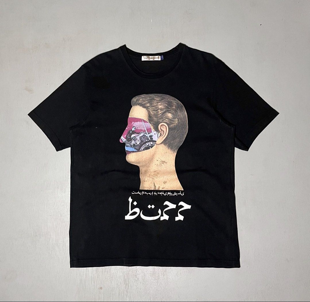 UNDERCOVER Co. Ltd Graphic Tee Black Size 3 (Category: Tshirts & Polo Shirts ) located in Catbalogan. Submitted by yellfindss (Listing ID 1466747069, Image 1). Description: - Brand: UNDERCOVER Co. Ltd. -21/28 - Color: Black - Size: 3 - Material: Cotton - Design: Large graphic of a human head cutout with motorcycle imagery and Arabic/Persian text on the front - Back: Solid black - Fit/Style: Classic crew neck, short sleeves.