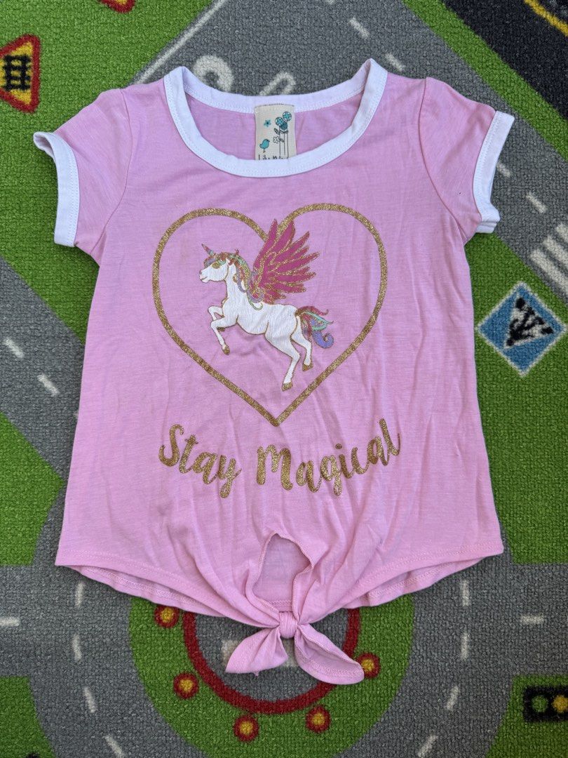 Unicorn Tied Front Tee Shirt (Category: Babies & Kids Fashion) located in Rizal. Submitted by preloovved (Listing ID 1466672992, Image 1). Description: Preloved, 6yo, Super cute pink unicorn shirt for little girls! Features a white ringer trim, gold glitter 'Stay Magical' graphic, and a trendy front tie-knot. super soft and comfy for everyday wear. Pink unicorn t-shirt for girls. Features a ‘Stay Magical’ graphic, white trim, and tie-front design