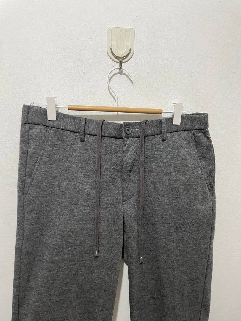 Uniqlo Grey Drawstring Jogger Pants Size L (Category: Joggers) located in Caloocan City. Submitted by alysoncala70121 (Listing ID 1466618862, Image 2). Description: - Brand: Uniqlo - Color: Grey - Size: Large (L) - Material: Soft knit - Features: Adjustable drawstring waist, button closure, and ribbed ankle cuffs - Pockets: Two front pockets and two back buttoned pockets - Design Detail: Stylish blue and white striped lining inside the waistband 