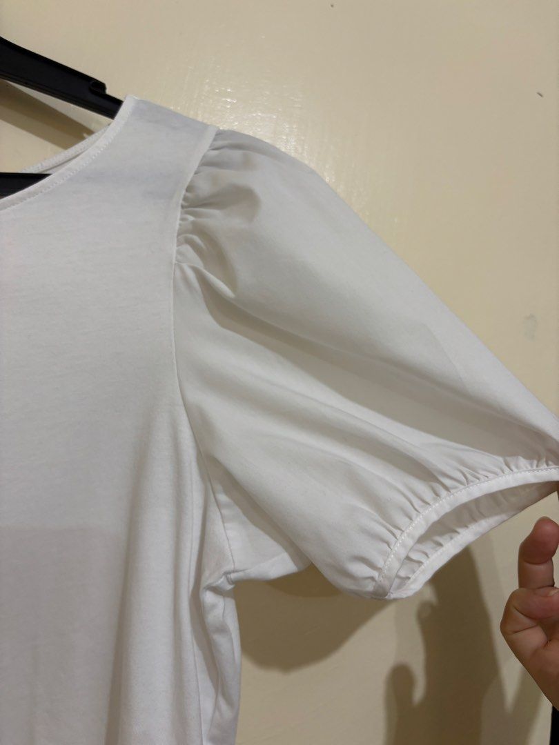 Uniqlo White Puff Sleeve Blouse (Category: Blouses) located in Balayan. Submitted by authenticfindsbymrb (Listing ID 1466706468, Image 2). Description: - Brand: Uniqlo - Color: White - Style: Rounded neckline with short puff sleeves - Material: Soft and comfortable cotton - Versatility: Easy to pair with skirts or pants for work or casual outings - Condition: Clean and ready to wear.