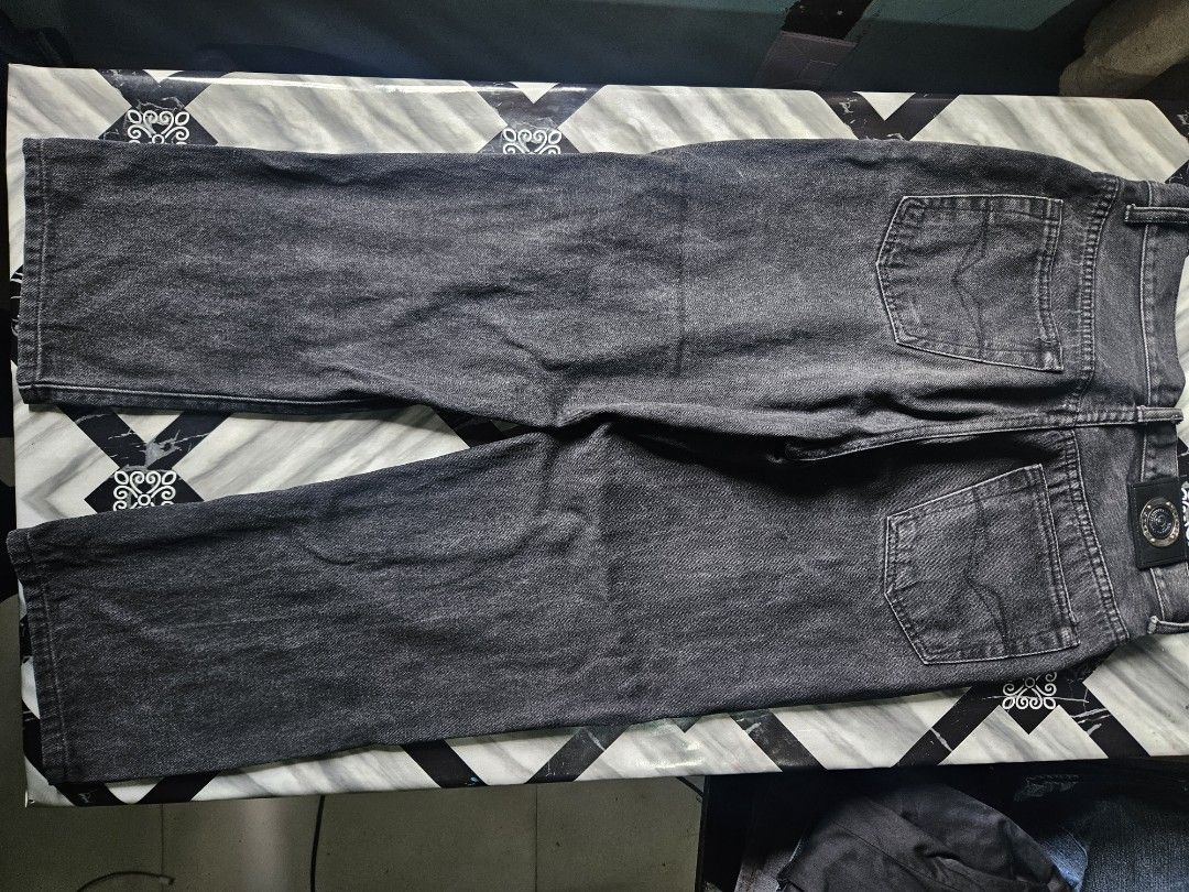 Versace Jeans Couture Black Denim Pants (Category: Jeans) located in Manila. Submitted by shanshan.river (Listing ID 1466592927, Image 2). Description: - Brand: Versace Jeans Couture - Style: Regular fit, straight leg denim pants - Color/Wash: Solid black dark wash - Closure: Zipper fly with branded buttons - Details: Signature logo patches on the waistband and front pocket - Design: Classic five-pocket layout - Condition: Excellent, well-maintai