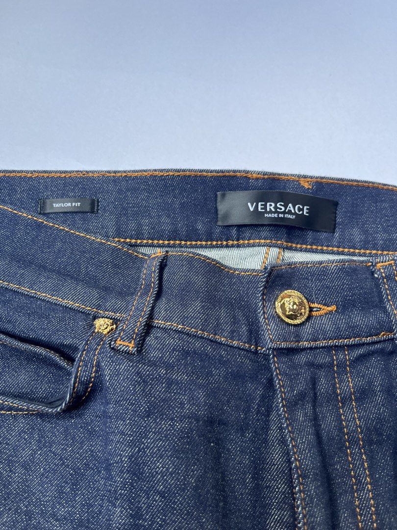 Versace Taylor Fit Dark Denim Jeans (Category: Jeans) located in Dumangas. Submitted by chiiieeef (Listing ID 1466566047, Image 2). Description: - Brand: Versace - Model: Taylor Fit Jeans - Color: Dark Indigo Denim - Material: Made in Italy - Design: Classic five-pocket setup with orange contrast stitching - Hardware: Gold-tone featuring the iconic Medusa head motif on button and rivets - Branding: Black leather rear waistband patch with embossed