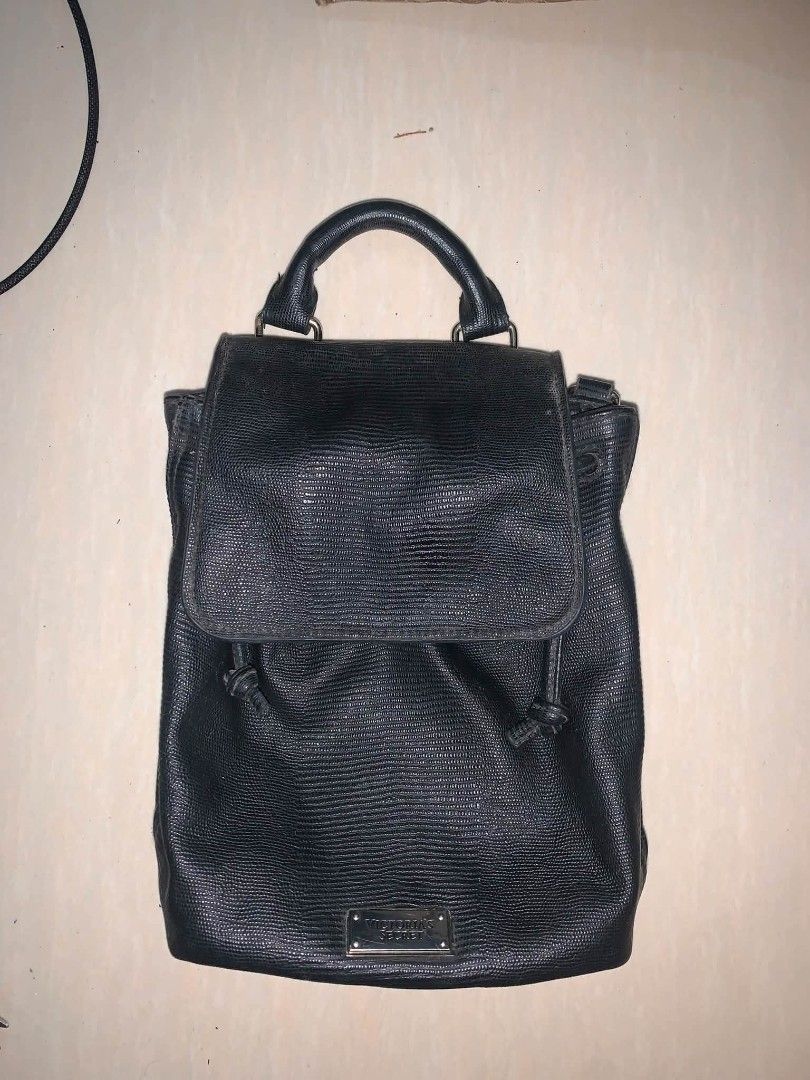 Victoria's Secret Black Textured Mini Backpack (Category: Backpacks) located in Tiaong. Submitted by cdoswan (Listing ID 1466622251, Image 1). Description: - Brand: Victoria's Secret - Material: Premium black faux leather with all-over textured pattern - Closure: Flap closure with secure drawstring mechanism underneath - Details: Signature metal logo plate on the front - Comfort & Carry: Top handle and adjustable shoulder straps - Size: Compact a