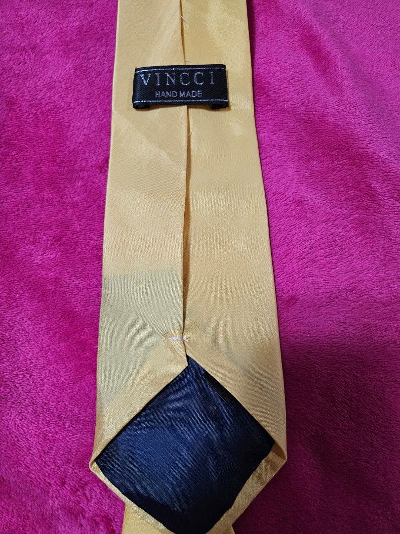 Vinci Hand Made Yellow Gold Necktie (Category: Ties) located in Caloocan City. Submitted by rm.diaz (Listing ID 1466741832, Image 2). Description: - Brand: Vincci - Color: Solid yellow gold with dark blue reverse lining - Construction: Hand-made with firm tag near the tail - Condition: Clean fabric throughout - Width: Standard blade width - Versatility: Easy to match with business and formal outfits, ideal for work or special events.