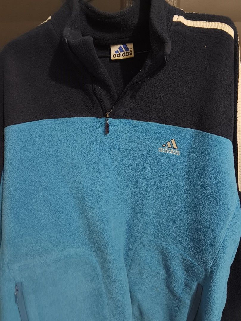 Vintage 90s Adidas 1/4 Zip Fleece Pullover (Category: Coats, Jackets and Outerwear) located in Manila. Submitted by j_hayden (Listing ID 1466755994, Image 1). Description: Rare Made In Syria Arabic Tag - Blue Two-Tone Colorblock Track Jacket Sweater Size L. secure zippered front pockets and embroidered Adidas logo on chest. This is a mid-1990s to early-2000s Adidas color-blocked quarter-zip fleece pullover featuring navy blue and light blue panel