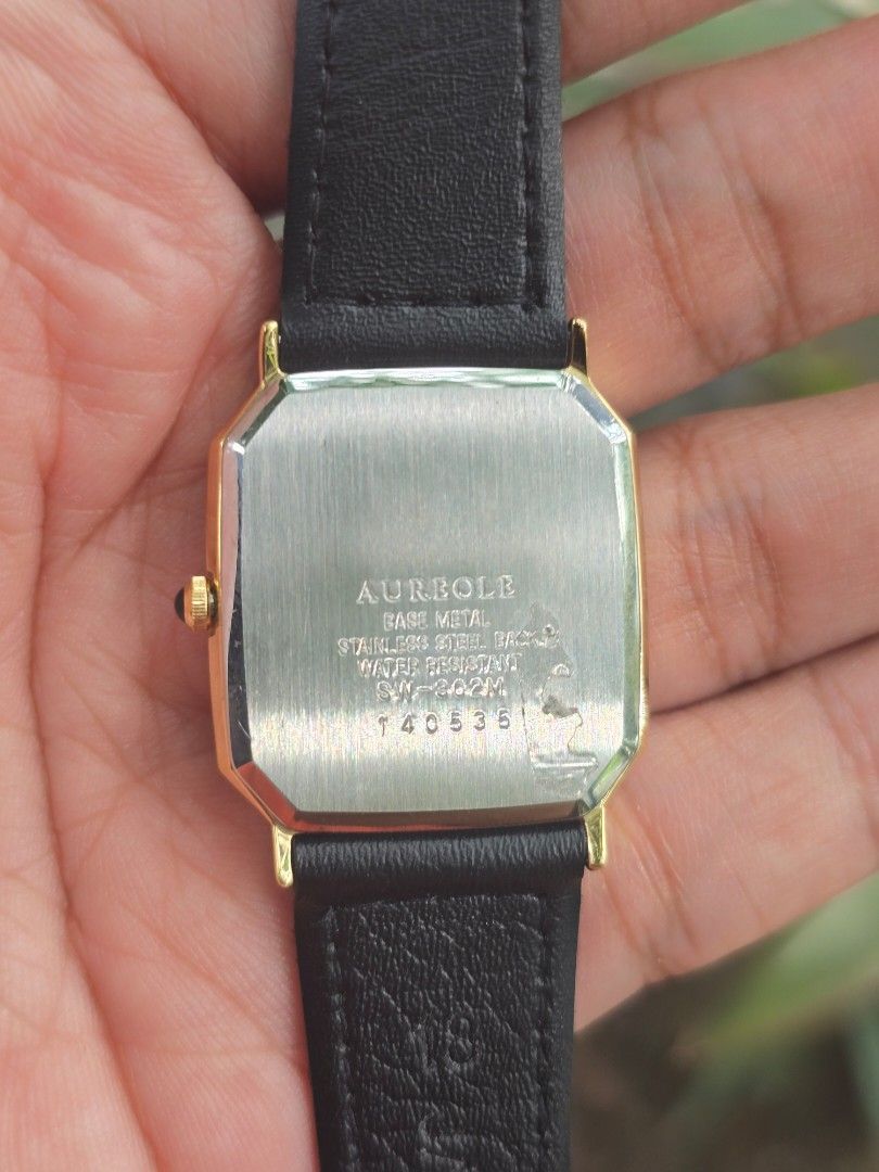 Vintage Aureole Swiss Tank Quart (Category: Luxury Watches) located in Manila. Submitted by timearcph (Listing ID 1466606315, Image 3). Description: • Case Style: Rectangular/octagonal "Tank" style case featuring an elegant, bark-textured or hammered finish on the gold-plated bezel. • Dial: Champagne/gold-toned vertical linen-textured dial. It features a minimalist layout with golden stick/baton hour indices and a clean, three-hand configuration 