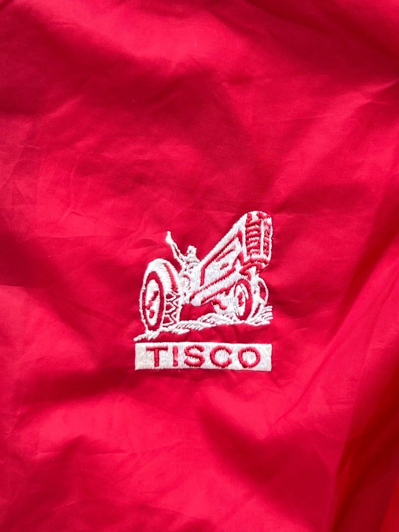 Vintage TISCO Red Nylon Coach Jacket Windbreaker (Category: Coats, Jackets and Outerwear) located in Caloocan City. Submitted by sillapwet0606 (Listing ID 1466569358, Image 2). Description: - Color: Vibrant red - Material: Lightweight nylon outer layer - Features: Pointed collar, snap-button front closure, and ribbed sleeve cuffs - Branding: White embroidered TISCO tractor logo on the chest - Versatility: Perfect casual outerwear to throw over a 