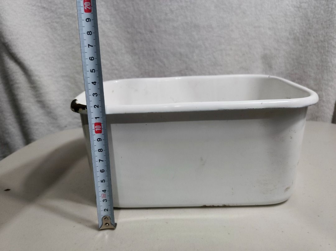 Vintage White Enamel Rectangular Basin Container Bowl (Category: Dinnerware & Cutlery) located in San Leonardo. Submitted by burgossanleonardo.12345 (Listing ID 1466693204, Image 3). Description: - Vintage white enamel rectangular container with rounded corners - Dimensions: approximately 20 cm in length - Sturdy and solid heavy metal base underneath - Features authentic rustic wear with minor chipping and rust around one corner rim - Versatile u