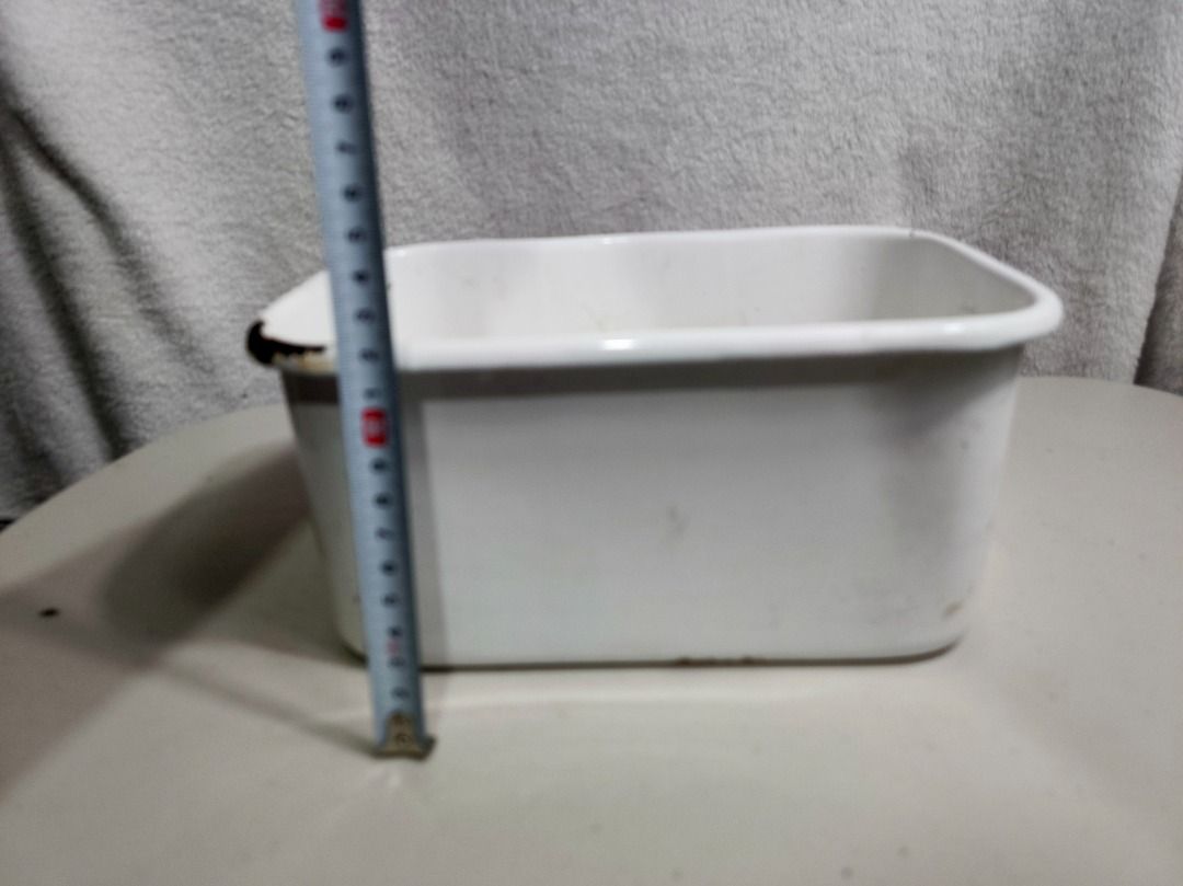Vintage White Enamel Rectangular Basin Container Bowl (Category: Dinnerware & Cutlery) located in San Leonardo. Submitted by burgossanleonardo.12345 (Listing ID 1466693204, Image 2). Description: - Vintage white enamel rectangular container with rounded corners - Dimensions: approximately 20 cm in length - Sturdy and solid heavy metal base underneath - Features authentic rustic wear with minor chipping and rust around one corner rim - Versatile u
