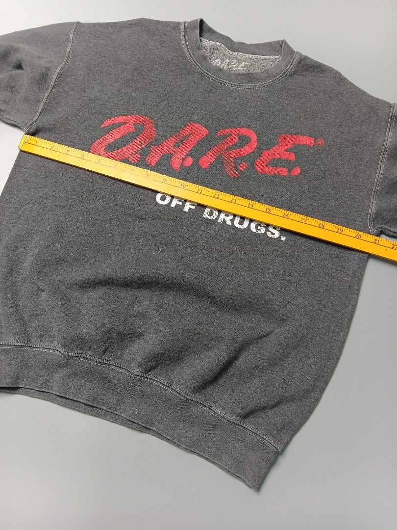 vintage-inspired D.A.R.E. pullover crewneck sweatshirt (Category: Coats, Jackets and Outerwear) located in Manila. Submitted by hustler_777 (Listing ID 1466667870, Image 3). Description: This specific type of screen-printed inner tag is characteristic of modern licensed apparel reproductions rather than authentic vintage items from the 1980s or 1990s (which typically utilized physical, stitched-in brand labels from manufacturers like Hanes, Fruit