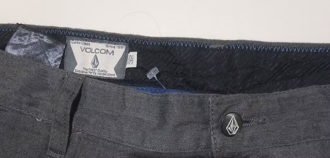 Volcom Men's Dark Grey Shorts Size 32 (Category: Shorts) located in San Carlos City. Submitted by dhong_abay_thrift (Listing ID 1466626692, Image 3). Description: - Brand: Volcom - Size: 32 - Color: Dark Grey - Closure: Button fly with iconic stone logo button - Details: Belt loops, dual back pockets, and stone logo patch - Style: Casual, solid color - Condition: Clean fabric, ready to wear.