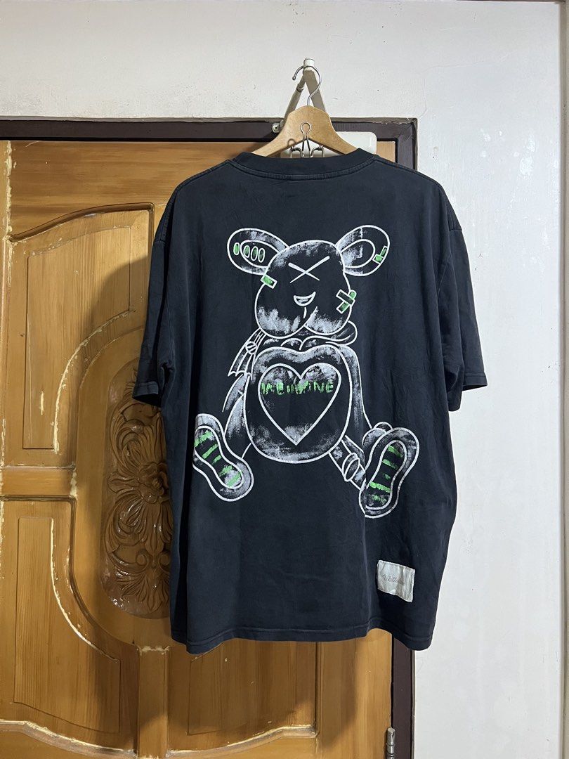 We11done Black Graphic Bear T-Shirt (Category: Tshirts & Polo Shirts ) located in Valencia. Submitted by thrifttomaniac_1225 (Listing ID 1466693178, Image 2). Description: - Color: Black - Fit: Relaxed oversized fit with crew neck - Details: Green & white chest pocket branding, large distressed teddy bear back graphic, and bottom hem woven label - Fabric: Soft washed look, great for streetwear - Condition: Brand new / Excellent quality.