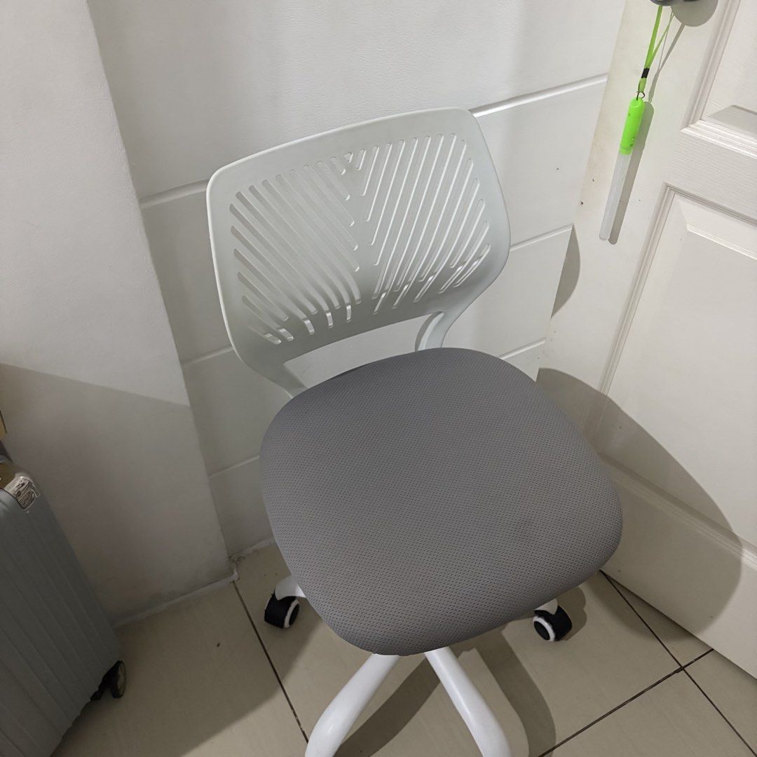 White and Grey Rolling Office Chair (Category: Office Furniture & Fixtures) located in Lucena. Submitted by chelseaabelar (Listing ID 1466693702, Image 3). Description: - Ergonomic rolling office chair with a modern white plastic frame - Breathable grey mesh seat and slatted backrest for all-day comfort - Height-adjustable lever located underneath for easy customization - Sturdy five-star white base with smooth-rolling caster wheels - Compact siz