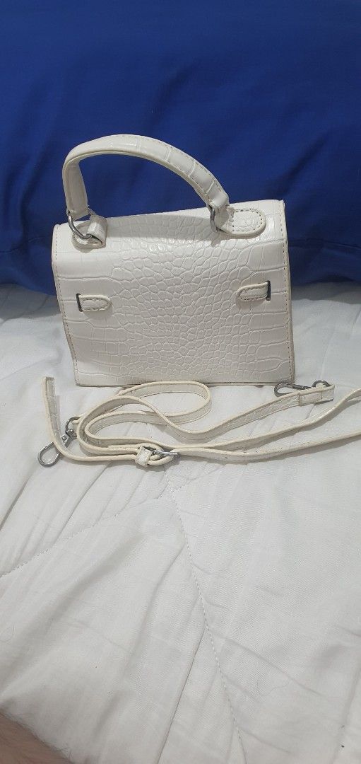White Crocodile Pattern Mini Handbag with Strap (Category: Cross-body Bags) located in Paranaque City. Submitted by personal_preloved40 (Listing ID 1466654480, Image 2). Description: - Color: White with stylish crocodile texture - Material: Premium faux leather with silver-tone hardware - Versatile carry: Includes single top handle and adjustable/removable shoulder strap - Interior: Clean black fabric lining with shape-preserving paper stuffing -