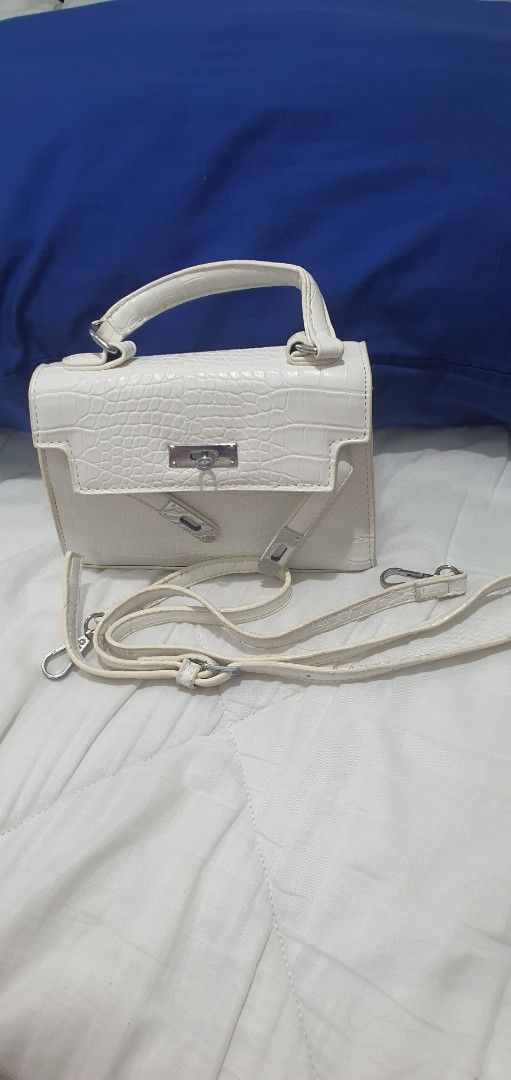 White Crocodile Pattern Mini Handbag with Strap (Category: Cross-body Bags) located in Paranaque City. Submitted by personal_preloved40 (Listing ID 1466654480, Image 1). Description: - Color: White with stylish crocodile texture - Material: Premium faux leather with silver-tone hardware - Versatile carry: Includes single top handle and adjustable/removable shoulder strap - Interior: Clean black fabric lining with shape-preserving paper stuffing -