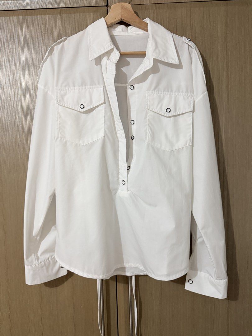 White utility button-down long sleeve shirt with back ties (Category: Longsleeves) located in Taguig. Submitted by mengxir20193848 (Listing ID 1466673728, Image 3). Description: - Color: White - Style: Long-sleeve button-down with utility chest flap pockets - Details: Collared neckline, front button placket, and shoulder epaulets - Fit Feature: Adjustable back tie strings for a flattering, cinched waist effect - Fabric: Crisp and high-quality mat