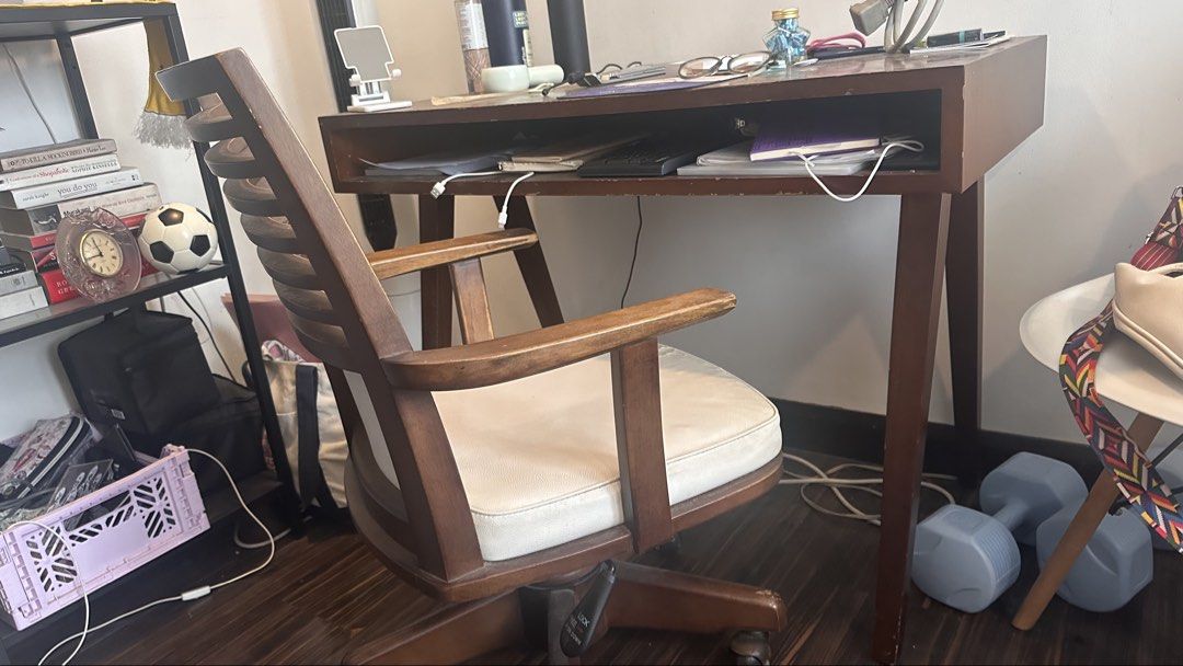 Wooden Study Desk with Rolling Office Chair (Category: Office Furniture & Fixtures) located in Quezon City. Submitted by earthbender24 (Listing ID 1466587083, Image 2). Description: - Mid-century style wooden desk and matching rolling office chair set - Rich brown wood finish with classic angled legs - Desk includes a built-in open storage slot for books, notebooks, or a keyboard - Chair features a slatted backrest, armrests, and a comfortable pa