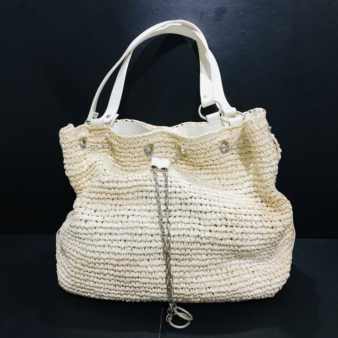 Woven straw bucket bag with silver chain (Category: Shoulder Bags) located in Baao. Submitted by all.things.japan (Listing ID 1466702236, Image 2). Description: 13 x 7 x 14.5 inches - Material: Cream-coloured woven straw with white faux leather straps - Hardware: Silver-tone accents and stylish hanging front chain detail - Closure: Secure drawstring top - Interior: Roomy and fully lined in white - Style: Versatile casual bag, ideal for beach trip