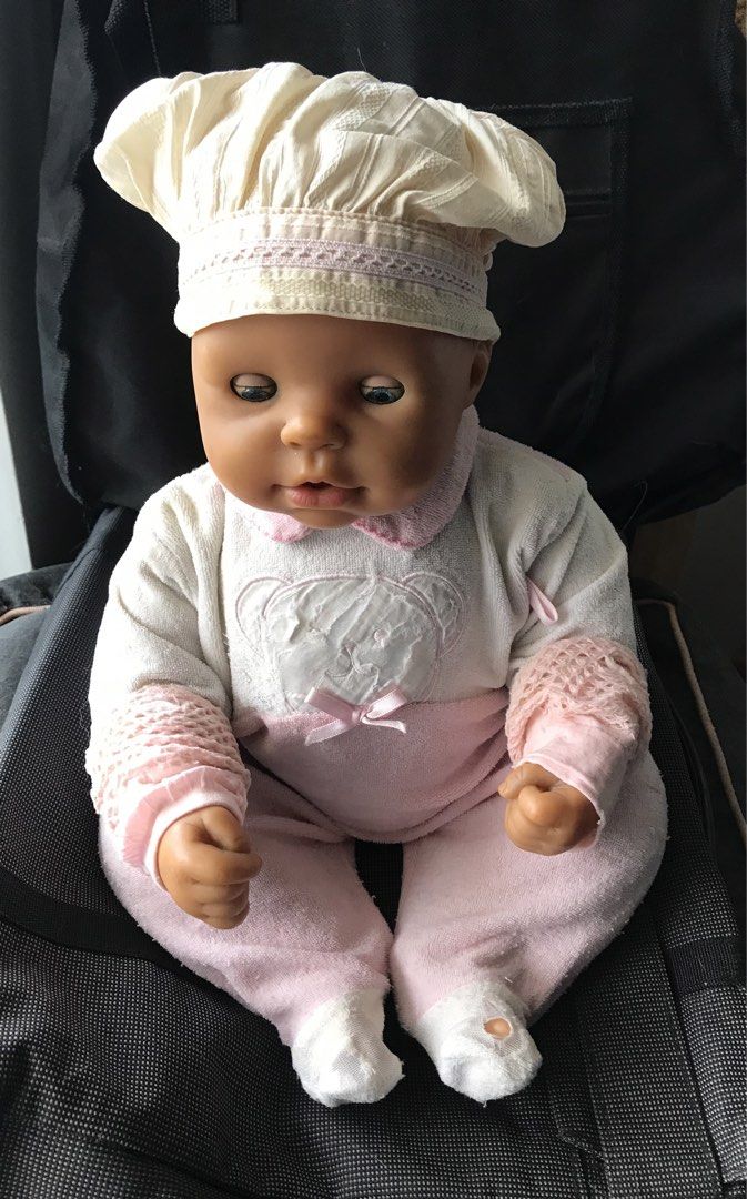 Zapf Creation Interactive Baby Doll with Stroller (Category: Babies & Kids Fashion) located in Quezon City. Submitted by 79moving (Listing ID 1466592925, Image 2). Description: - Authentic Zapf Creation baby doll - White and pink teddy bear top, matching pants, and chef-style hat - Body: Soft body construction for cuddling - Battery-operated mechanism / *NOT WORKING* (need repair) - Authenticity: Stamped branding on the back compartment - Well us