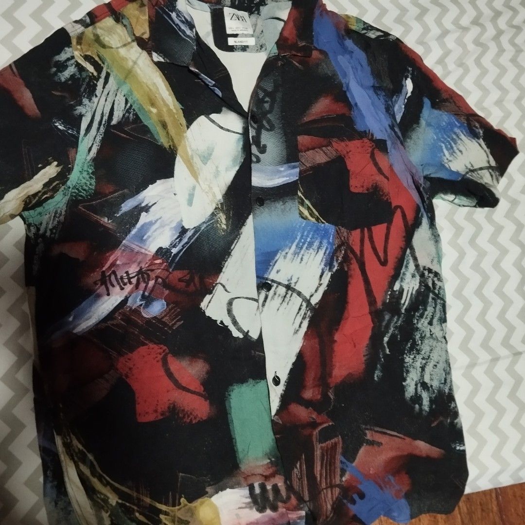 Zara large polo (Category: Tshirts & Polo Shirts ) located in Manila. Submitted by lene48 (Listing ID 1466627472, Image 3). Description: - Brand: Zara - Size: Large (EUR L / USA L / MEX 42) - Fit: Relaxed fit - Design: Artistic abstract brush stroke pattern with vibrant colors (red, blue, green, black, white) - Condition: Good pre-loved condition (7/10) - Details: Short sleeves, button-down collar, chest pocket.