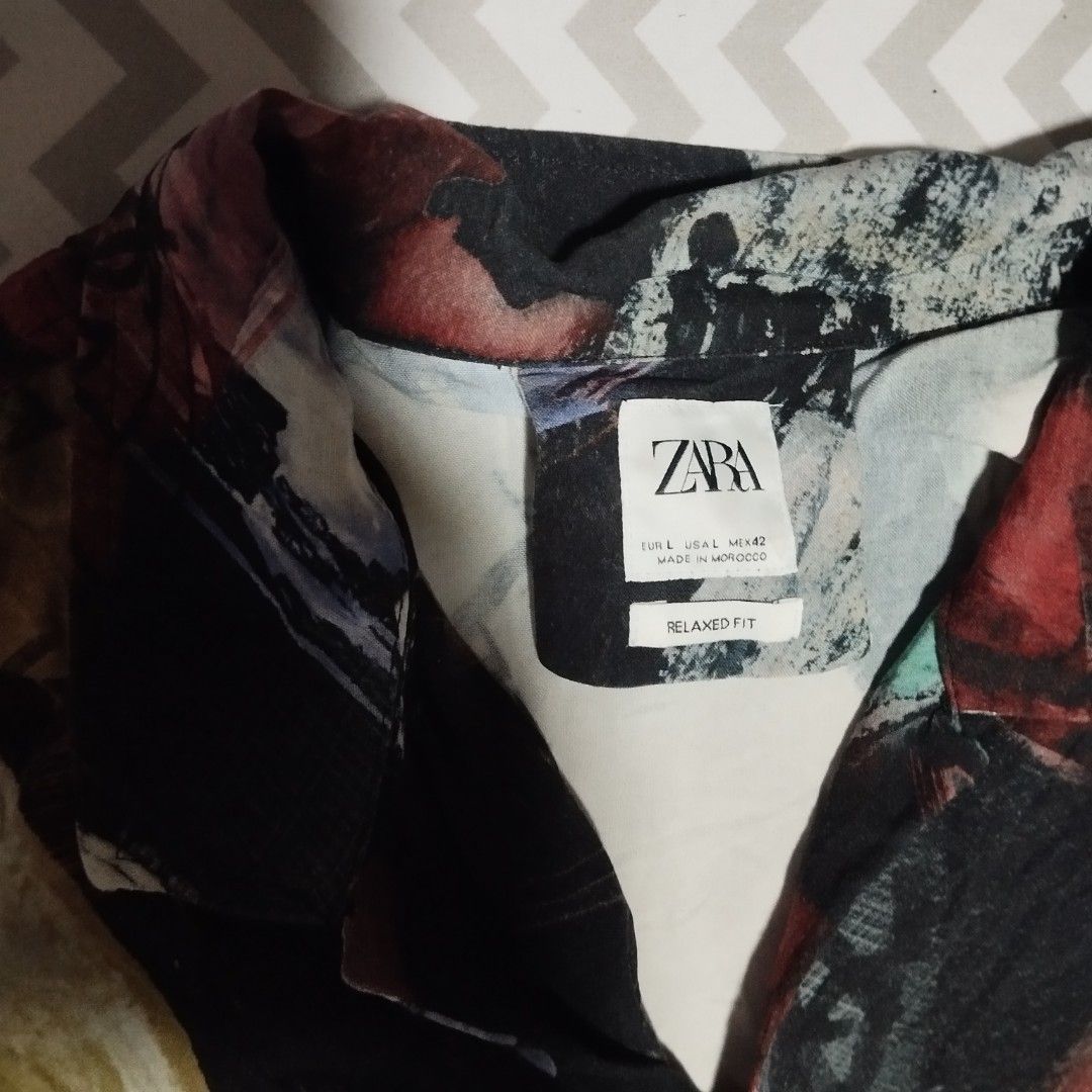 Zara large polo (Category: Tshirts & Polo Shirts ) located in Manila. Submitted by lene48 (Listing ID 1466627472, Image 2). Description: - Brand: Zara - Size: Large (EUR L / USA L / MEX 42) - Fit: Relaxed fit - Design: Artistic abstract brush stroke pattern with vibrant colors (red, blue, green, black, white) - Condition: Good pre-loved condition (7/10) - Details: Short sleeves, button-down collar, chest pocket.