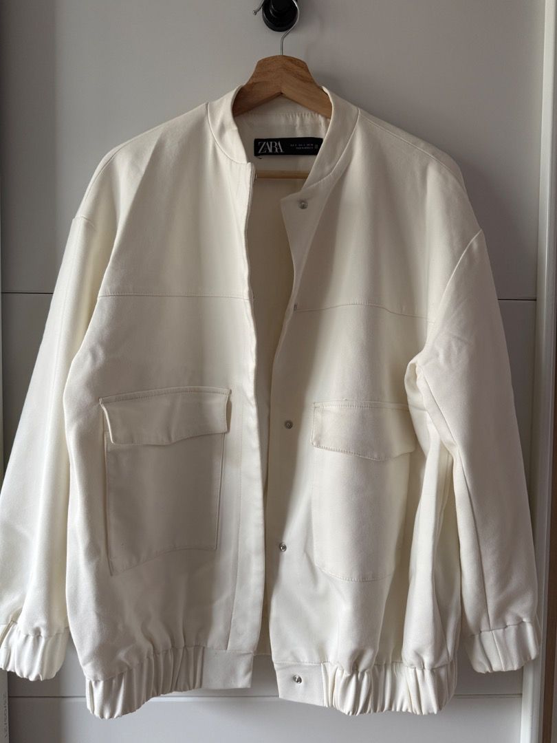 ZARA Off-White Bomber Jacket (Category: Coats, Jackets and Outerwear) located in Mandaluyong City. Submitted by _curatedbypat (Listing ID 1466700673, Image 2). Description: - Brand: ZARA (bought from EU) - Color: All Off-white - Condition: good, clean inside and out - Closure: Snap-button front with clean collarless neckline - Pockets: Two roomy front pockets with flaps - Fit: Relaxed, slightly oversized with gathered elastic cuffs and hemline - 