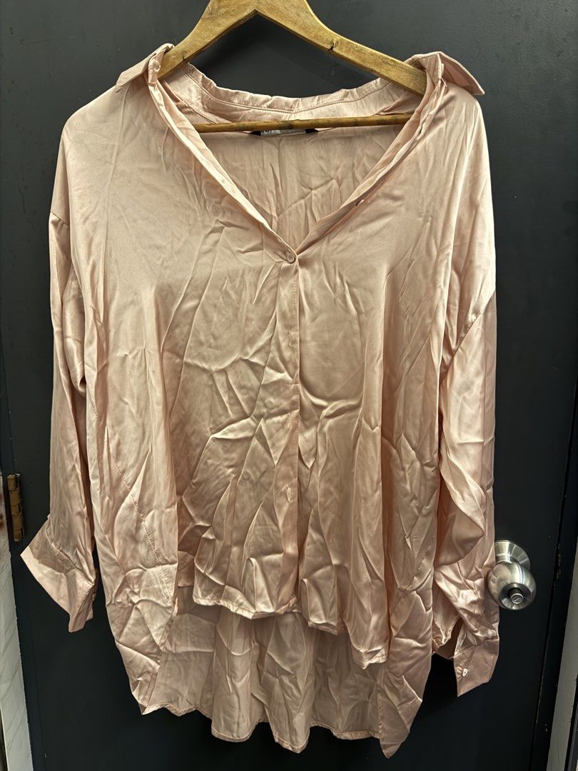 Zara Pink Satin Oversized Button-Up Blouse Size L (Category: Blouses) located in Makati City. Submitted by 099baby (Listing ID 1466694558, Image 1). Description: Oversized Zara button-up shirt in light pink satin finish. Classic collar, long sleeves with button cuffs, and a longer curved hem in the back. Labeled size L..