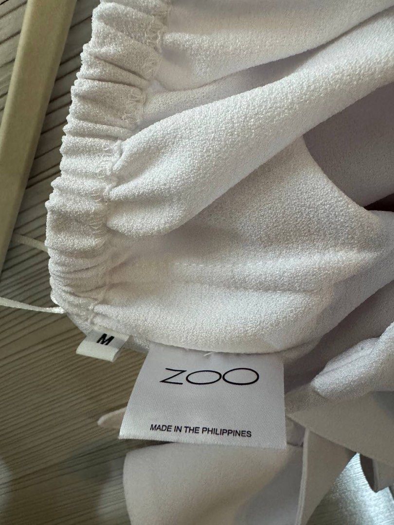 Zoo White Off-Shoulder Top Size M (Category: Blouses) located in Taguig. Submitted by anxmz (Listing ID 1466606584, Image 3). Description: - Brand: Zoo - Size: Medium - Color: White - Style: Off-shoulder with thin straps and draped long sleeves - Material: Lightweight fabric - Origin: Made in the Philippines.