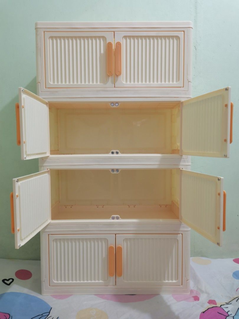 4-Tier Foldable Plastic Storage Cabinet with Doors (Category: Storage Boxes & Baskets) located in Valenzuela. Submitted by nafie330 (Listing ID 1466806715, Image 2). Description: - Color: Creamy white with stylish orange handles - Dimensions: 92 cm (H) x 50 cm (W) x 24 cm (D) - Design: 4-tier stackable, modular setup with textured door panels - Features: Magnetic door closures and a foldable design for easy assembly - Material: Sturdy, durable pl