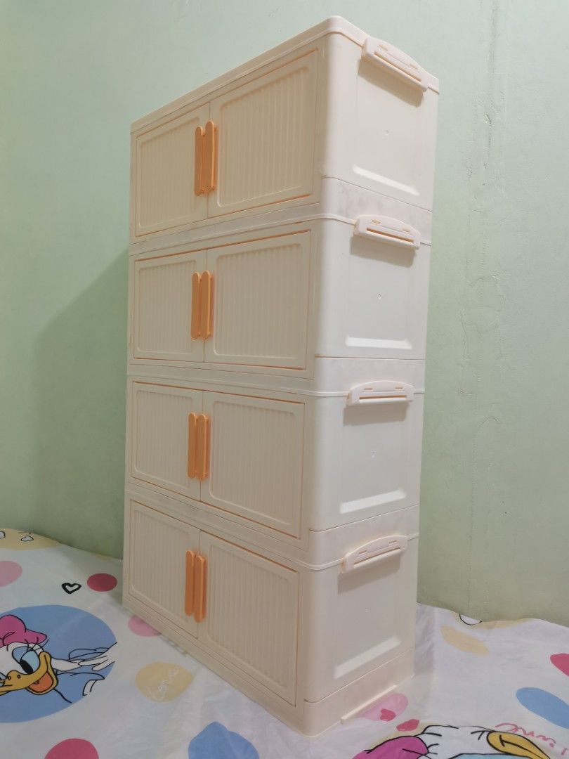 4-Tier Foldable Plastic Storage Cabinet with Doors (Category: Storage Boxes & Baskets) located in Valenzuela. Submitted by nafie330 (Listing ID 1466806715, Image 3). Description: - Color: Creamy white with stylish orange handles - Dimensions: 92 cm (H) x 50 cm (W) x 24 cm (D) - Design: 4-tier stackable, modular setup with textured door panels - Features: Magnetic door closures and a foldable design for easy assembly - Material: Sturdy, durable pl