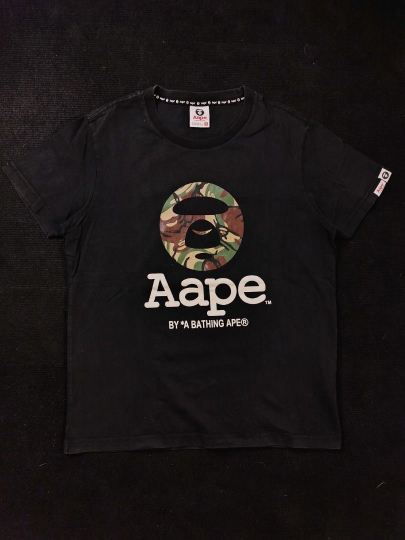 Aape CAMOU (Category: Tshirts & Polo Shirts ) located in San Fernando. Submitted by gaboo_asncn (Listing ID 1466905529, Image 2). Description: - Aape CAMOU - Size: 2XL on tag (W21/L26) - Condition: Excellent - Color Rate: 8.5/10 - No issue Take note: The shirt is black, and since the carpet/background is also black, the color may look slightly faded or less vibrant in the photos. In actual lighting, the shirt has a normal black color..