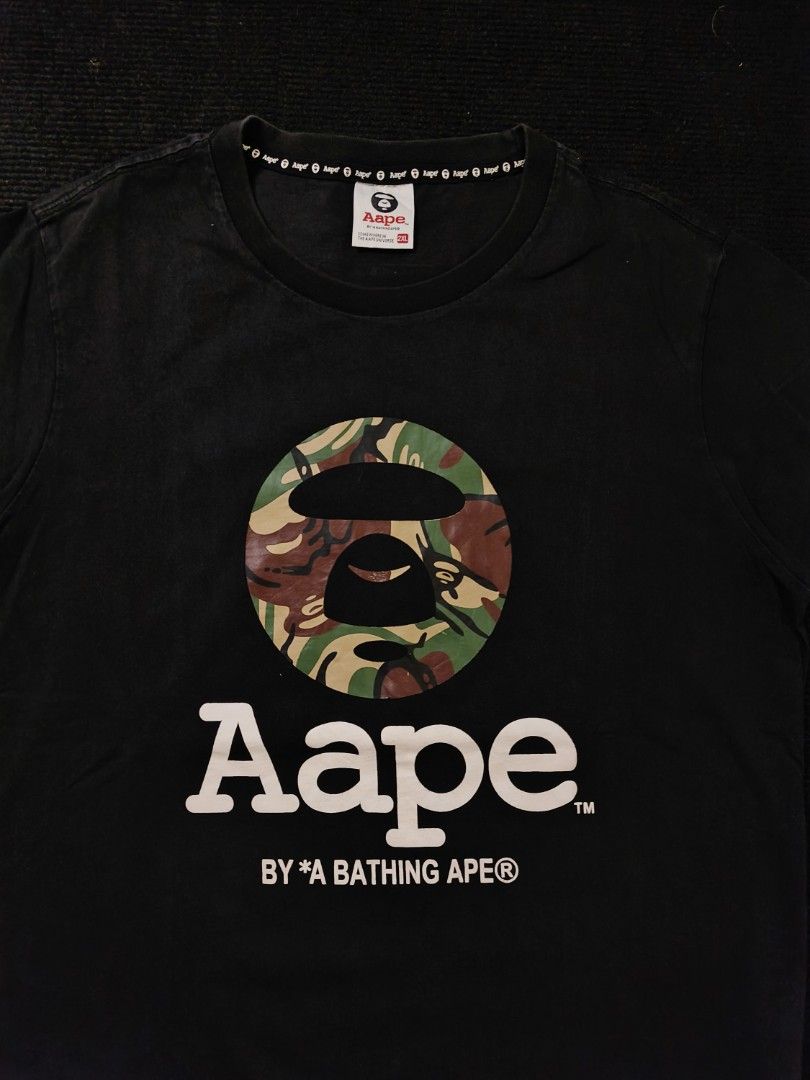 Aape CAMOU (Category: Tshirts & Polo Shirts ) located in San Fernando. Submitted by gaboo_asncn (Listing ID 1466905529, Image 3). Description: - Aape CAMOU - Size: 2XL on tag (W21/L26) - Condition: Excellent - Color Rate: 8.5/10 - No issue Take note: The shirt is black, and since the carpet/background is also black, the color may look slightly faded or less vibrant in the photos. In actual lighting, the shirt has a normal black color..