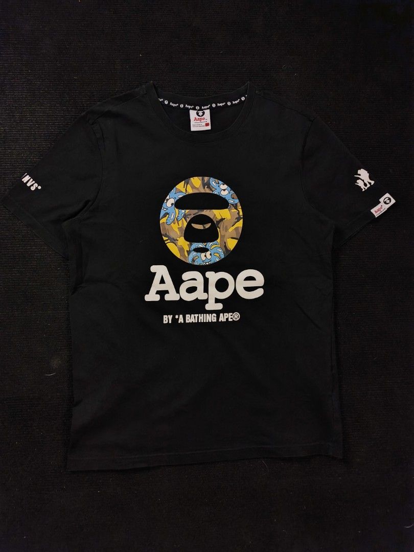 Aape Yellow Blue Camou (Category: Tshirts & Polo Shirts ) located in San Fernando. Submitted by gaboo_asncn (Listing ID 1466933637, Image 2). Description: - Aape Yellow Blue Camou - Size: XL on tag (W20/L27) - Condition: Excellent - Color Rate: 9.5/10 - No issue Take note: The shirt is black, and since the carpet/background is also black, the color may look slightly faded or less vibrant in the photos. In actual lighting, the shirt has a normal b
