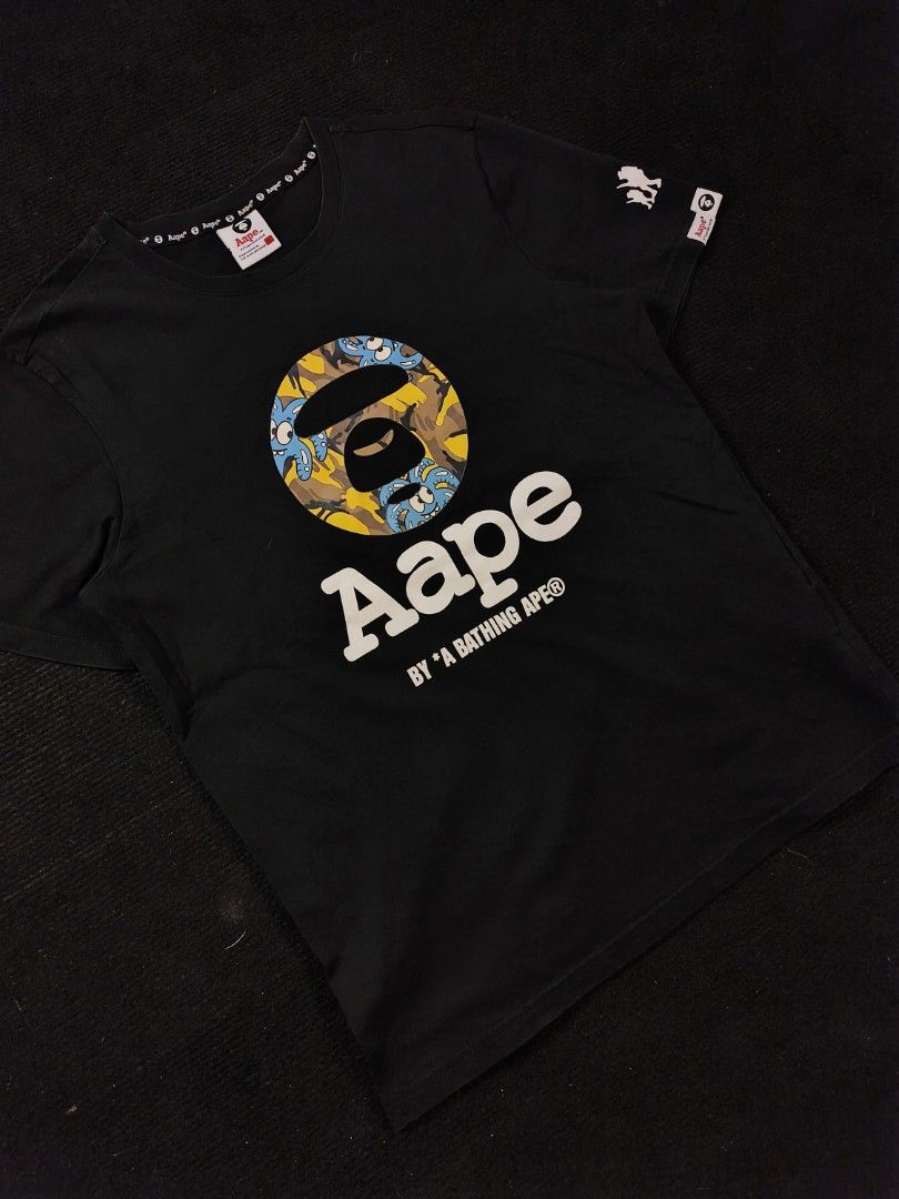 Aape Yellow Blue Camou (Category: Tshirts & Polo Shirts ) located in San Fernando. Submitted by gaboo_asncn (Listing ID 1466933637, Image 1). Description: - Aape Yellow Blue Camou - Size: XL on tag (W20/L27) - Condition: Excellent - Color Rate: 9.5/10 - No issue Take note: The shirt is black, and since the carpet/background is also black, the color may look slightly faded or less vibrant in the photos. In actual lighting, the shirt has a normal b