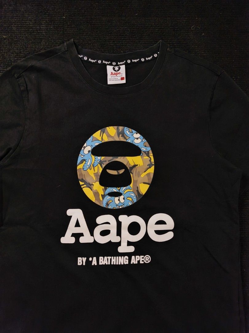 Aape Yellow Blue Camou (Category: Tshirts & Polo Shirts ) located in San Fernando. Submitted by gaboo_asncn (Listing ID 1466933637, Image 3). Description: - Aape Yellow Blue Camou - Size: XL on tag (W20/L27) - Condition: Excellent - Color Rate: 9.5/10 - No issue Take note: The shirt is black, and since the carpet/background is also black, the color may look slightly faded or less vibrant in the photos. In actual lighting, the shirt has a normal b