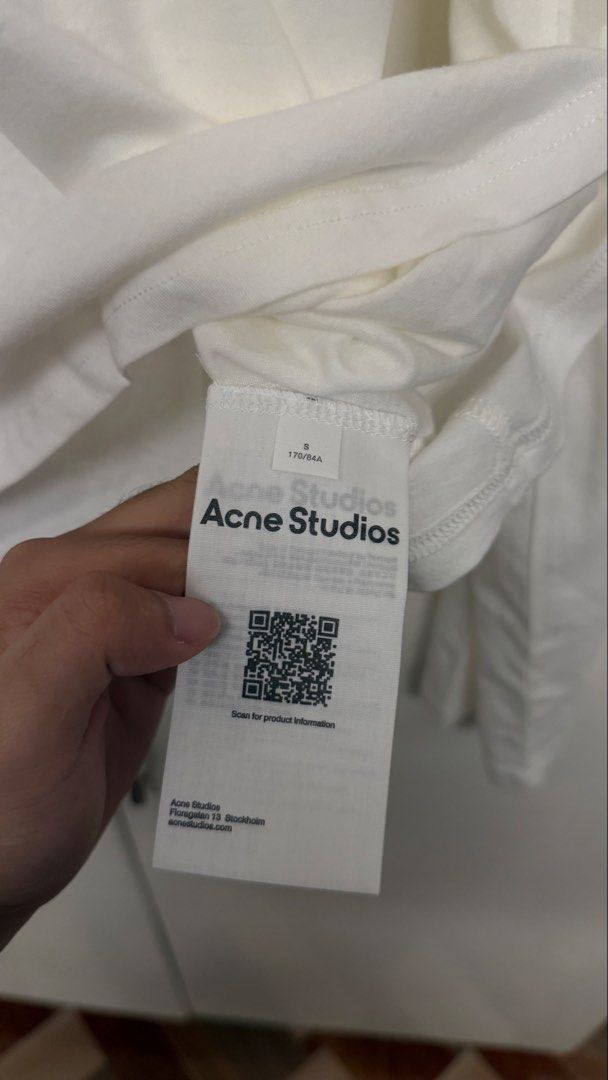 Acne Studios Long Sleeve White T-Shirt Size S (Category: Coats, Jackets and Outerwear) located in Calamba. Submitted by migsdeclutter (Listing ID 1466845928, Image 3). Description: - Brand: Acne Studios - Item: White long-sleeve tee with striking black logo print wrapping around the sleeve - Size: S Runs Big 25 x 29 - Material: Premium clean white cotton - Authenticity: Interior care tags and QR code tag attached - Condition: Excellent, well-main