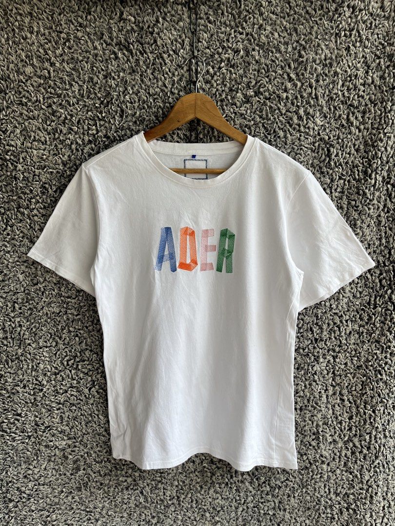 Ader Error Embroidered Logo Tee | Size M to L (Category: Shirts) located in General Trias. Submitted by zrchustle.604 (Listing ID 1466823357, Image 1). Description: Ader Error Embroidered Logo Tee featuring a distinctive multi-color textured logo graphic across the chest. • Design: Short-sleeve cotton crewneck t-shirt in white with a colorful embroidered "ADER" block letter graphic on the front. • Details: Features the signature multi-colored emb