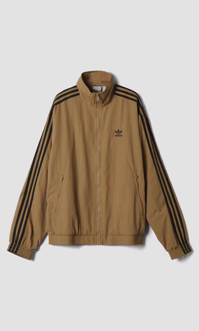 Adidas Brown Track Jacket with Black Stripes (Category: Coats, Jackets and Outerwear) located in Manila. Submitted by manifest_05 (Listing ID 1466916326, Image 1). Description: Brown track jacket from Adidas. Classic three stripes in black running down both sleeves. Features a high collar, full front zip, and zipped side pockets. Elastic cuffs and hem. Embroidered trefoil logo on the chest..