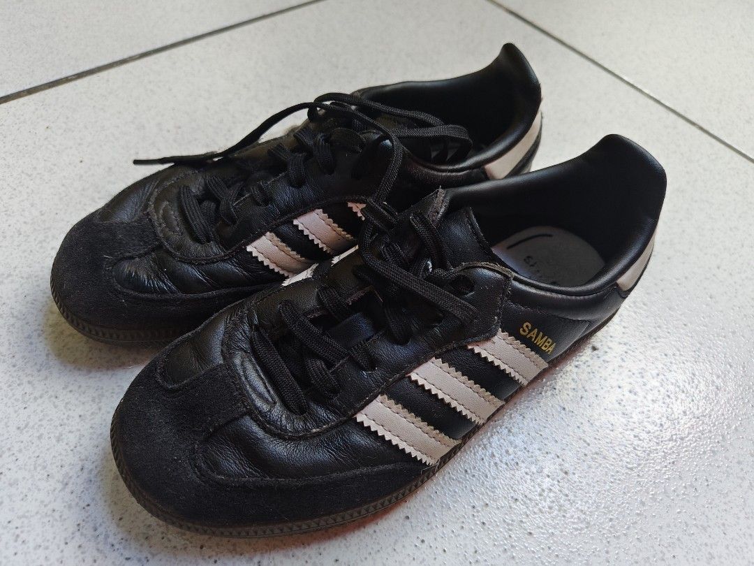 Adidas Samba Black White Sneakers (Category: Babies & Kids Fashion) located in Quezon City. Submitted by chagchag28 (Listing ID 1466803102, Image 2). Description: Adidas Samba sneakers in black leather with white stripes. Classic gum sole and suede toe cap. Gold SAMBA lettering printed on the side. Normal signs of wear on the leather uppers and outsoles. Inner insoles show some wear. Standard lace-up closure. Timeless retro footwear style..