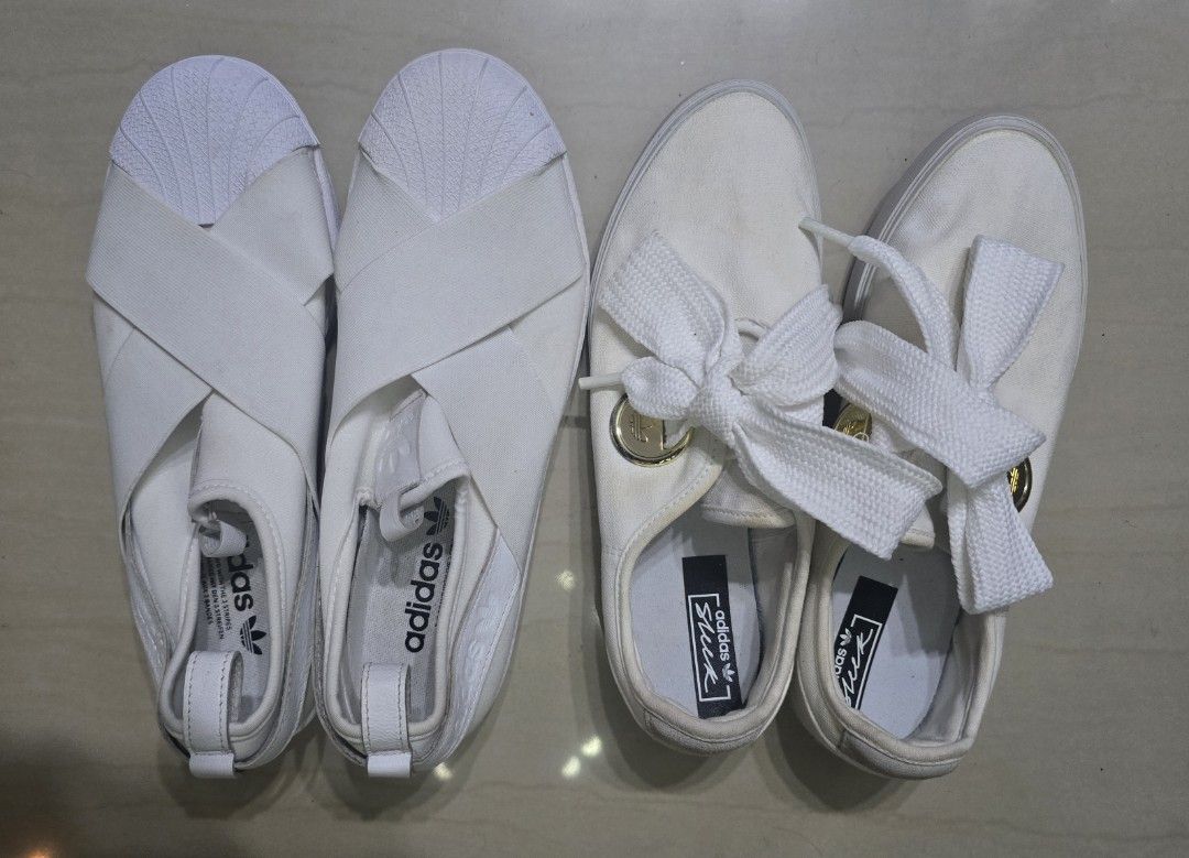 Adidas White Slip-On Sneaker Bundle (Category: Sneakers) located in Manila. Submitted by brandedshoppe_mnl (Listing ID 1466924260, Image 2). Description: 100% Original adidas sneakers -Unused/Shoes only, no box -Two pairs of white Adidas slip-on sneakers. One pair has thick laces tied in big bows with gold hardware accents. The other pair features wide elastic cross straps over the top and shell toes. -Both are size US 8, clean white canvas and r