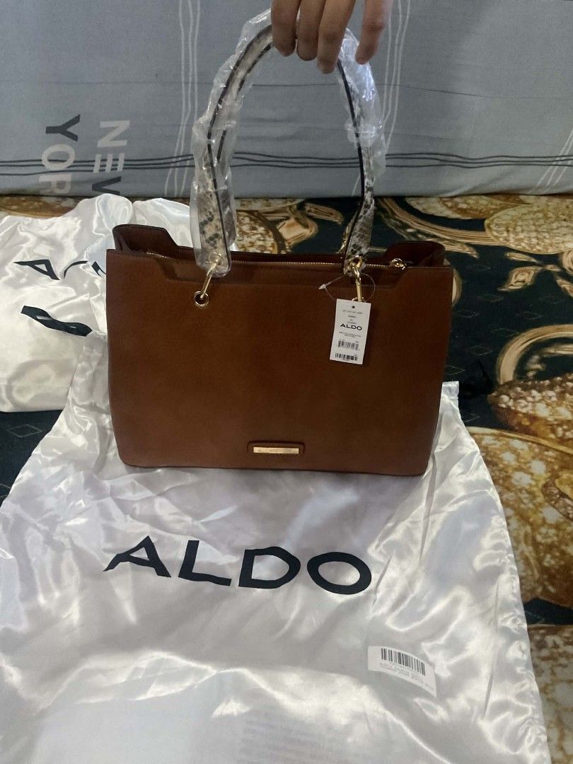 Aldo bag (Category: Tote Bags) located in Dasmarinas. Submitted by erljapan (Listing ID 1466915338, Image 2). Description: The item in the image is the ALDO Hareli Tote Bag (shown in a medium beige/tan synthetic finish with a patterned strap). [1, 2] Product Details: Brand: ALDO Style: Hareli Tote Bag Material: Synthetic / vegan leather Dimensions: Approximately 37.5 cm (L) × 13.5 cm (W) × 25.5 cm (H) Features: Top-zip closure, structured 3-compa