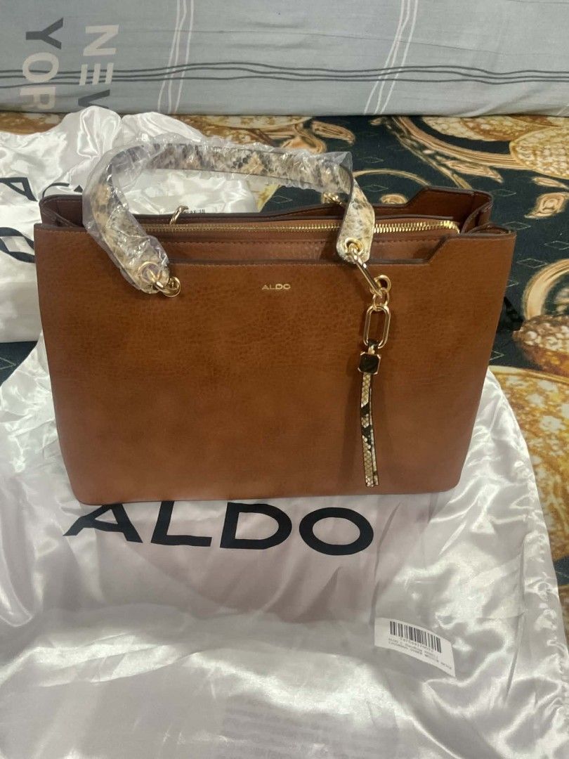 Aldo bag (Category: Tote Bags) located in Dasmarinas. Submitted by erljapan (Listing ID 1466915338, Image 3). Description: The item in the image is the ALDO Hareli Tote Bag (shown in a medium beige/tan synthetic finish with a patterned strap). [1, 2] Product Details: Brand: ALDO Style: Hareli Tote Bag Material: Synthetic / vegan leather Dimensions: Approximately 37.5 cm (L) × 13.5 cm (W) × 25.5 cm (H) Features: Top-zip closure, structured 3-compa