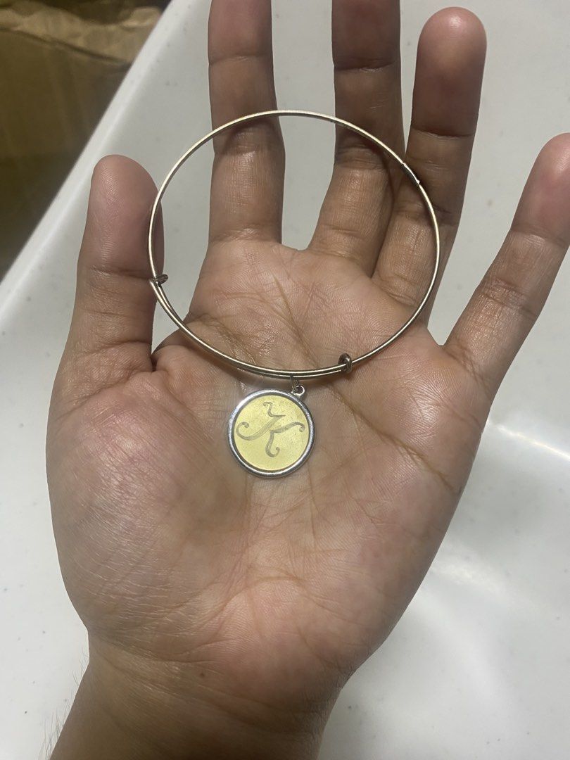 Alex and Ani Initial Letter K Charm Bangle (Category: Bracelets) located in Pasacao. Submitted by wengpullar37205 (Listing ID 1466938080, Image 2). Description: - Brand: Alex and Ani - Design: Silver-tone wire expandable bangle - Charm: Round charm with engraved letter 'K' on a yellowish background - Authenticity: Stamped with Alex and Ani logo and 925 energy hallmarks on the back - Fit: Adjustable design fits most wrist sizes easily - Condition: