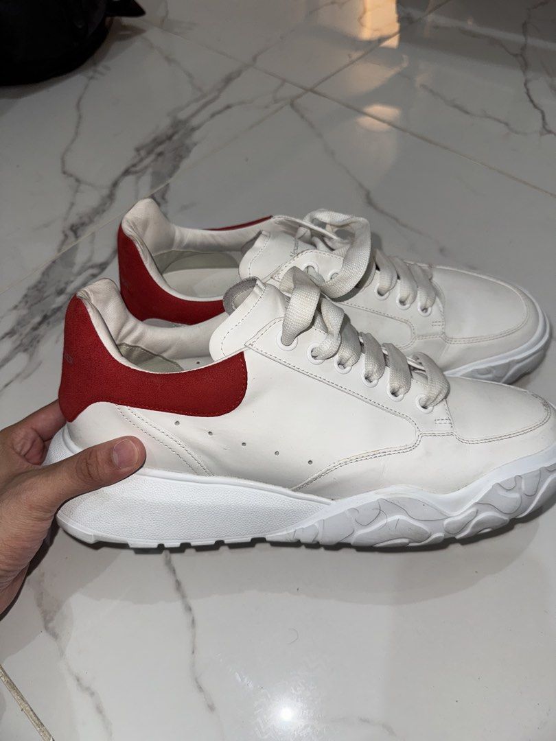 Alexander McQueen White and Red Leather Sneakers (Category: Sneakers) located in Manila. Submitted by herreradav92264 (Listing ID 1466827905, Image 1). Description: - Color & Style: White leather with striking red heel counters for a designer look - Sole & Laces: Trendy chunky sculpted rubber sole with thick white laces - Condition: Clean upper with minor creases from light wear - Comfort: Well-padded collar for extra ankle comfort - DM for inqui
