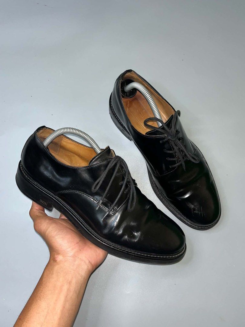 Ami Paris Black Leather Derby Shoes (Category: Dress Shoes) located in Pagadian. Submitted by smoothproc. (Listing ID 1466929524, Image 2). Description: - Brand: Ami Paris - Style: Black leather derby shoes with a glossy finish - Details: Classic lace-up closure, rounded toe profile, sturdy stacked heel, and leather lining with branded insoles - Condition: Shows normal scuffs and creasing from regular wear; soles have decent tread left - Versatil